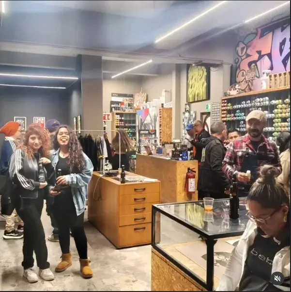 Grupo de visitantes reunidos en una tienda con vitrinas, piezas de colección y estantes
