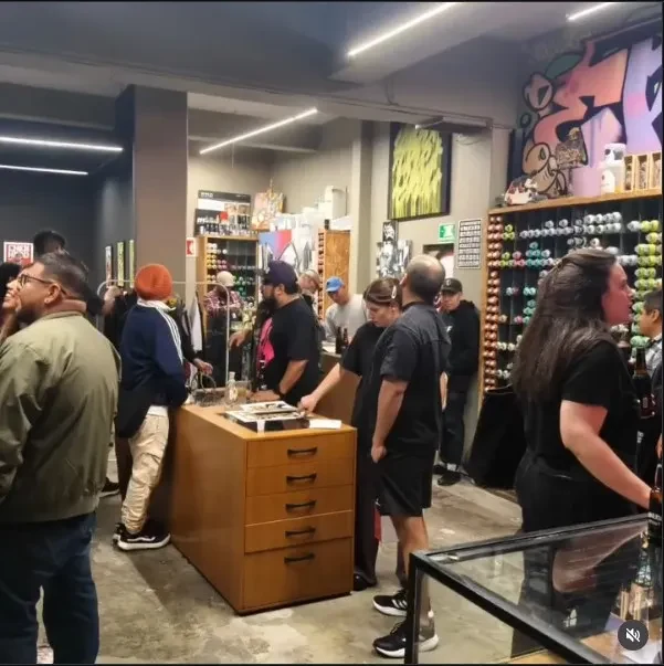 Visitantes reunidos alrededor de vitrinas y estantes con figuras y objetos de colección